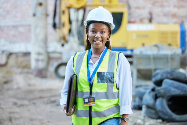 ingénieure, ouvrière de la construction ou architecte heureuse se sentant fière et satisfaite des opportunités de carrière. portrait d’un employé ou d’un gestionnaire noir travaillant sur un chantier - ouvrier du bâtiment photos et images de collection