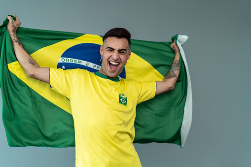 Portrait of a young man holding Brazilian flag