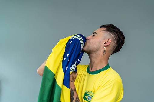 Young man kissing Brazilian flag