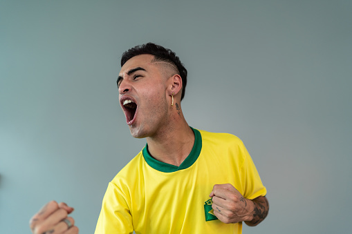 Young man celebrating Brazilian team winning