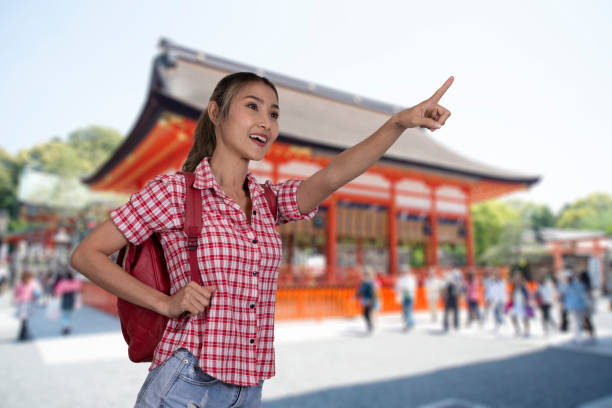 istock Female tourist stands in buddhist temple pointing her hand forward. 1430860013