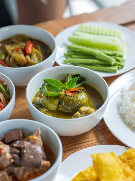 istock Green curry in a white ceramic cups is served alongside other Thai dishes on the table. Thai food, selective focus. 1430862006