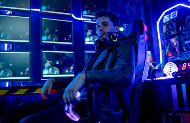 istock Smart man sit on chair and look at camera also stay in room with multicolor light. Concept of expert and professional of game and streaming for business. 1430863127