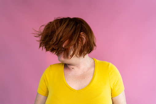 Mid adult woman dancing tossing hair on a studio shot
