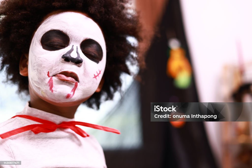 Halloween Celebrating Halloween. A boy with Halloween makes up and dressed in a Halloween party devil costume Bizarre Stock Photo