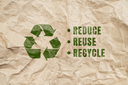 Símbolo de reciclaje verde sobre fondo de papel arrugado marrón de un embalaje de papel. concepto ecológico y salvar el mundo photo