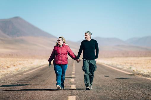 Couple walking on an empty road at Atacama desert