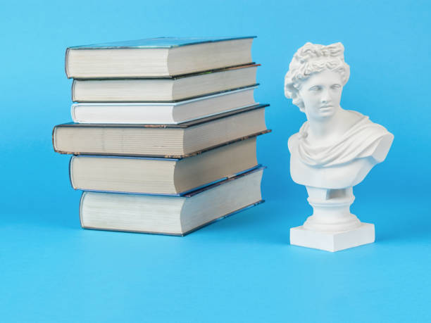 ein stapel bücher und eine gipsstatuette auf hellblauem grund. minimales konzept. - roman statue stock-fotos und bilder