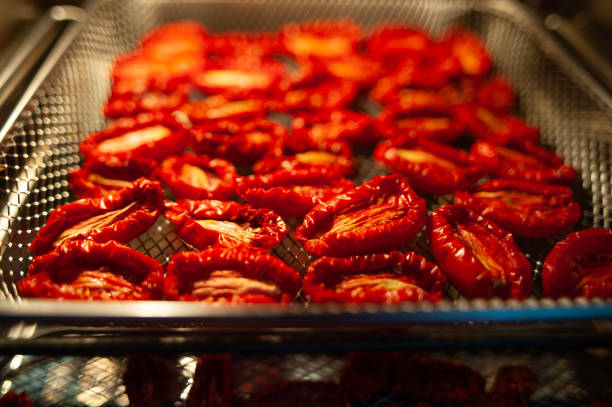 Sun-dried tomatoes on a baking sheet, the process of making dried tomatoes  tomatoes