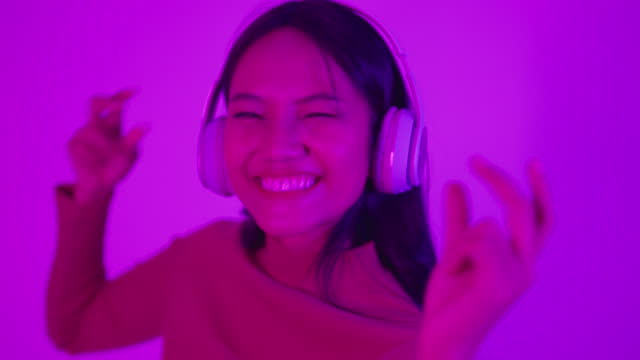 Happy young asian woman in neon party.
