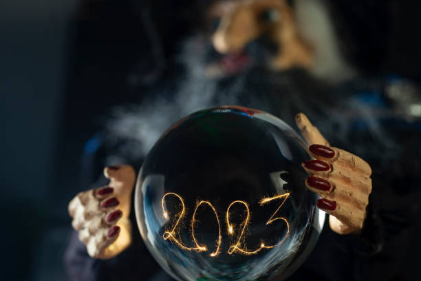 2023 written with sparklers and sparks, inside a crystal ball.
