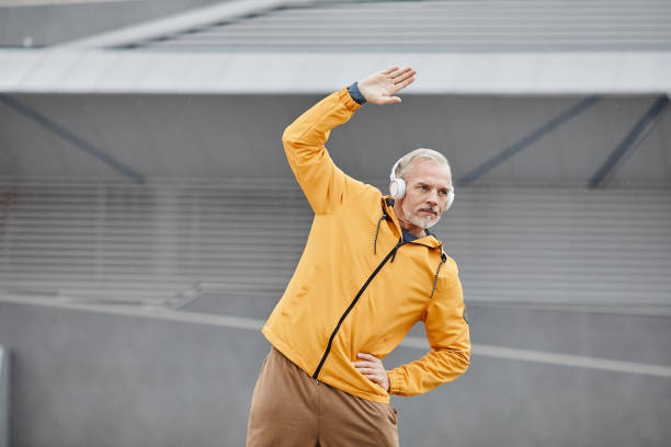 active mature man stretching in stadium - log fire audio imagens e fotografias de stock