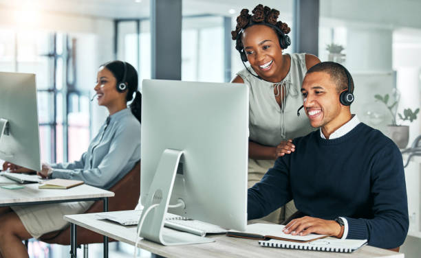 apoyo, capacitación y entrenamiento, un gerente de centro de llamadas está feliz de ayudar a su equipo. colaboración, liderazgo y trabajo en equipo en una startup tecnológica. diversidad de oficinas, hombres y mujeres jóvenes que trabajan con computad - centro de llamadas fotografías e imágenes de stock