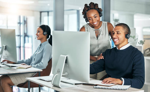 istock Manager training call center agent on computer with talking, discussing and negotiating deals, sales and promotions for customer. Office colleagues leader helping learning intern with client on tech 1430915717