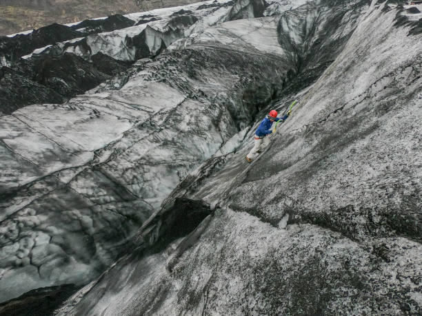 istock Man ice climbing inside a glacier crevasse in Iceland 1430917628