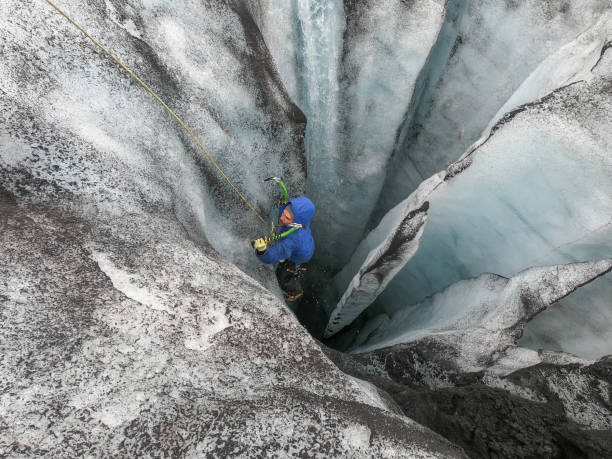 istock Man ice climbing inside a glacier crevasse in Iceland 1430917765