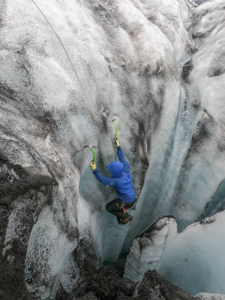 istock Man ice climbing inside a glacier crevasse in Iceland 1430917782