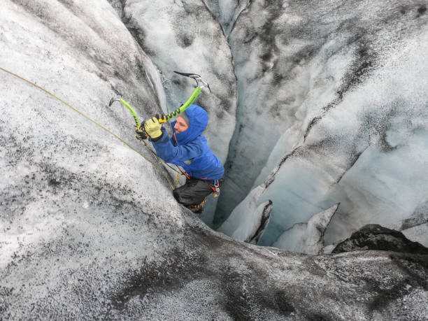 istock Man ice climbing inside a glacier crevasse in Iceland 1430917808