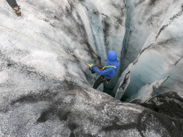 istock Man ice climbing inside a glacier crevasse in Iceland 1430917835