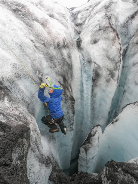 istock Man ice climbing inside a glacier crevasse in Iceland 1430917856