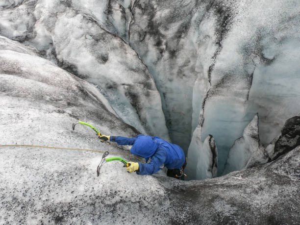 istock Man ice climbing inside a glacier crevasse in Iceland 1430917903