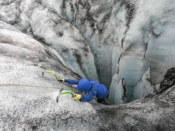 Photo of Man ice climbing inside a glacier crevasse in Iceland