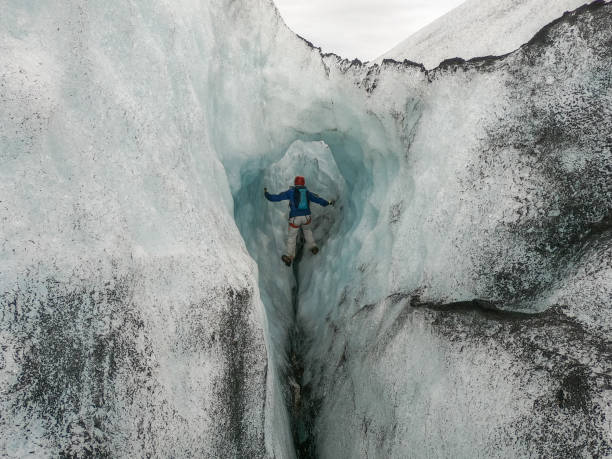 istock Man ice climbing inside a glacier crevasse in Iceland 1430917921