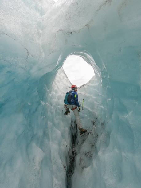 istock Man ice climbing inside a glacier crevasse in Iceland 1430918003