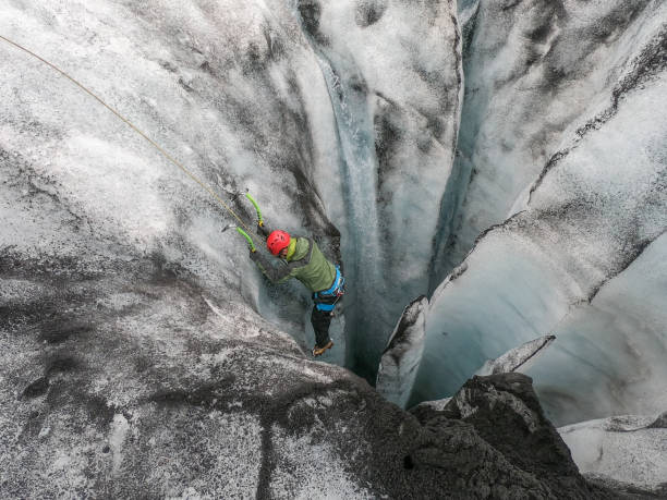 istock Man ice climbing inside a glacier crevasse in Iceland 1430918020
