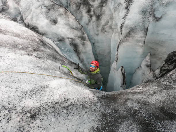 istock Man ice climbing inside a glacier crevasse in Iceland 1430918022