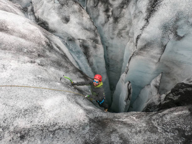 istock Man ice climbing inside a glacier crevasse in Iceland 1430918079
