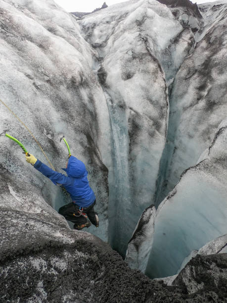 istock Man ice climbing inside a glacier crevasse in Iceland 1430918142