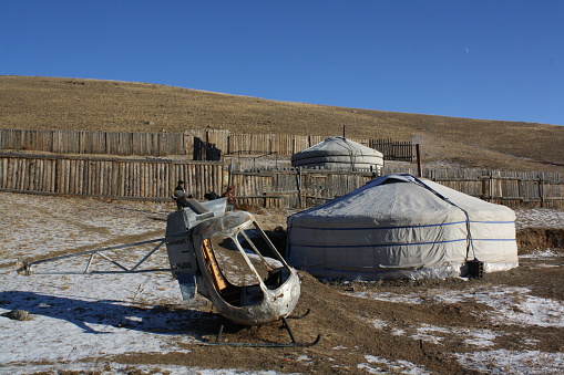 A nomadic tent (ger) and the wrecked helicopter in the long winter, Chingeltei valley, near Ulaanbaatar, Tuv, Mongolia. The winter is long and freezing in the country. Staying inside the nomadic tent (ger) is warmer as the wind blows strongly each day.