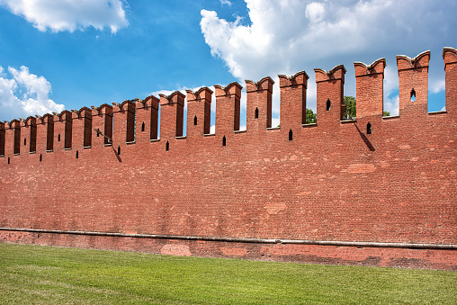 The famous Kremlin wall with dovetail crenellations. The texture of the red ancient brick Kremlin wall