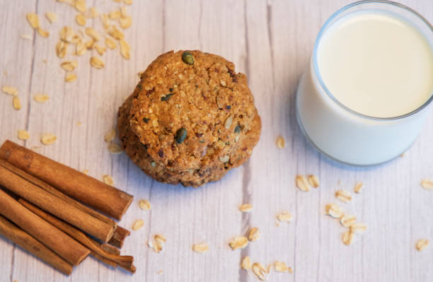 Oatmeal cookies, milk and cinnamon on the  wooden background stock photo
