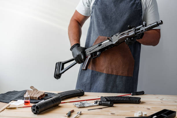 istock Close up of young man in apron disassembling a gun above the table 1430926547