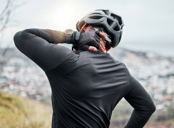 Closeup of a man suffering an injury while out cycling outside. Unknown male with an injured back. Person with a stiff, sore, problem causing him backache and discomfort. Arthritis affects posture primer plano de un hombre que sufre una lesión mientras anda en bicicleta afuera. varón desconocido con la espalda lesionada. persona con un problema rígido, dolorido, que le causa dolor de espalda e incomodidad. la artritis afecta la postura