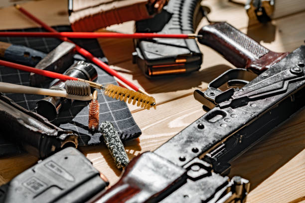 istock Black disassembled shotgun and cleaning tools on wooden table . 1430930993