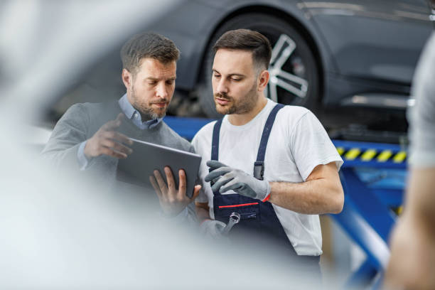 istock Male customer and auto mechanic using touchpad in a workshop. 1430941029