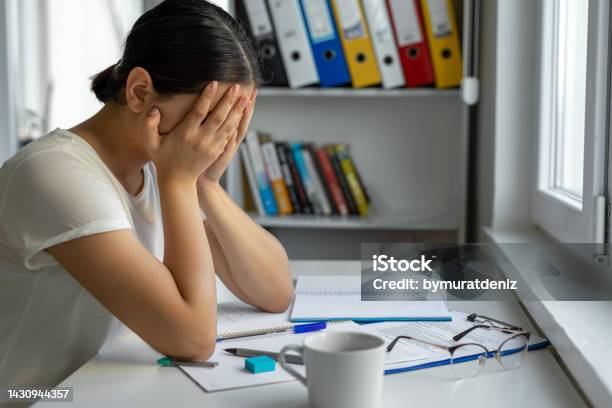 University Student Sadeness Alone While Sitting On Table Doing Homework Stock Photo - Download Image Now
