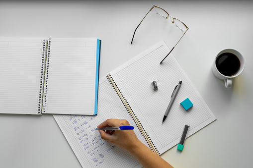 Student girl writing in her notebook at table