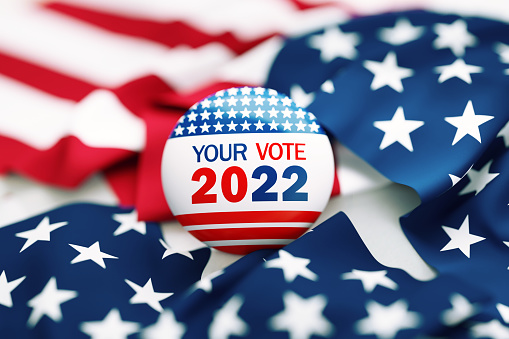 Your Vote 2022 written badge sitting on blue background. Great use for election and voting concepts. 2022 US Midterm Election concept. High angle view.