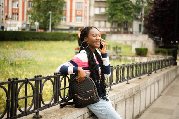 Portrait of a young African  woman enjoying outdoors and telephoning stock photo
