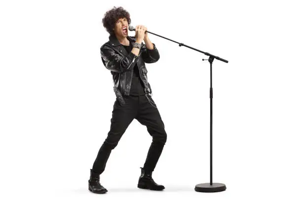 Photo of Rock singer in a leather jacket singing loud on a microphone