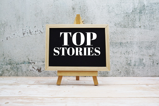 Top Stories word on blackboard stand on wooden background