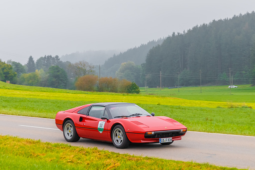 Gessertshausen, Germany - September 25, 2022: 1980 Ferrari 308 GTS italian oldtimer vintage sports car in a picturesque landscape.