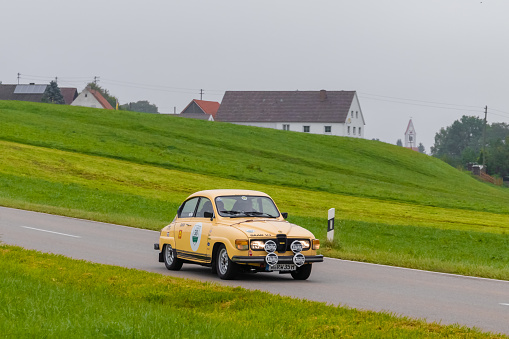 Gessertshausen, Germany - September 25, 2022: 1979 Saab 96 swedish oldtimer vintage rallye racing car in a picturesque landscape.