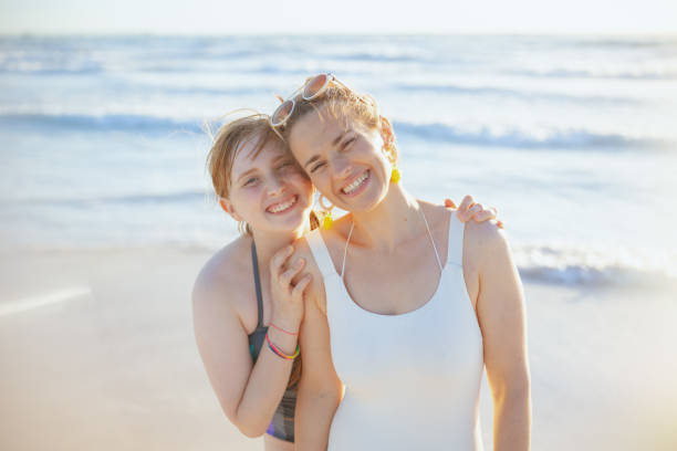 portrait d’une mère et d’une adolescente heureuses et élégantes à la plage - only teenage girls teenager adolescence sea photos et images de collection