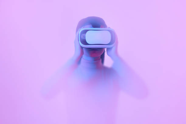 istock Young girl wearing VR headset immersed in backlit diffuse liquid. Concept of art, metaverse, modern technology, video games and virtual reality 1430960212