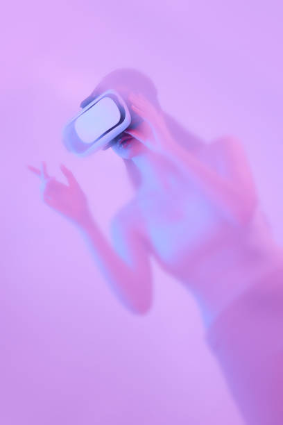 istock Young girl wearing VR headset immersed in backlit diffuse liquid. Concept of art, metaverse, modern technology, video games and virtual reality 1430960253
